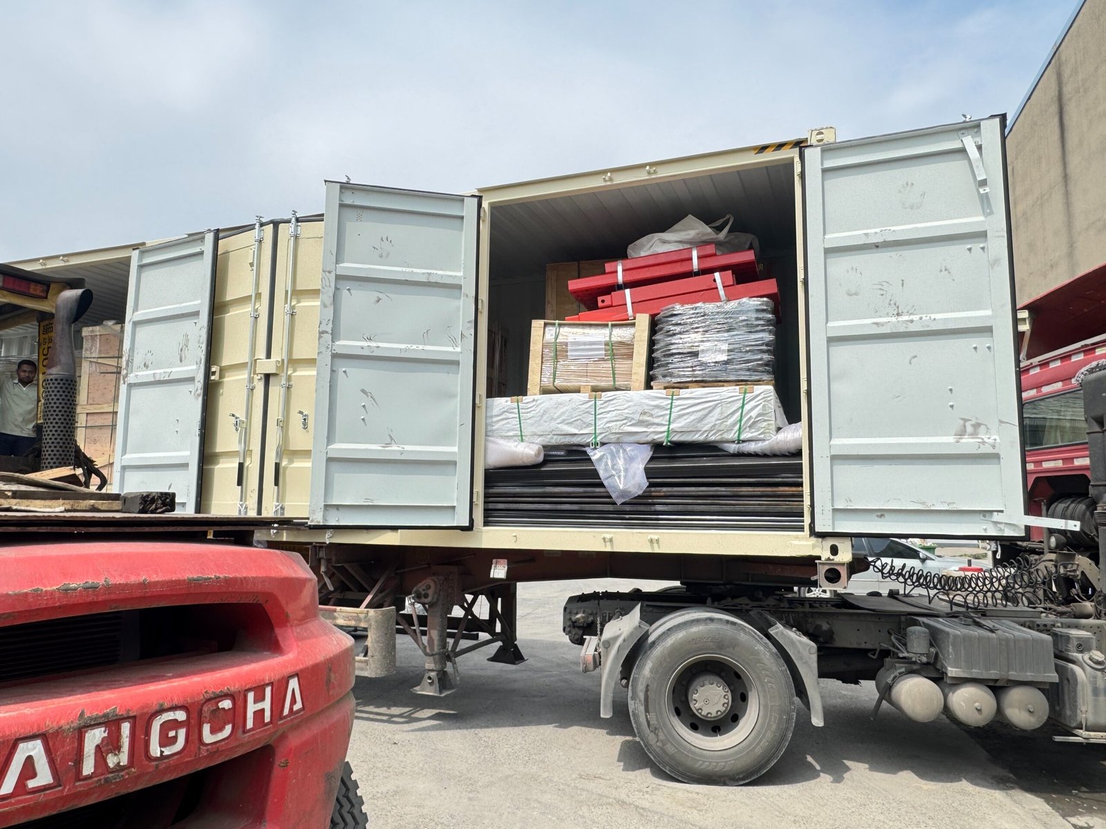 Team members at JEES Global loading building supplies for international shipment from a Chinese warehouse.