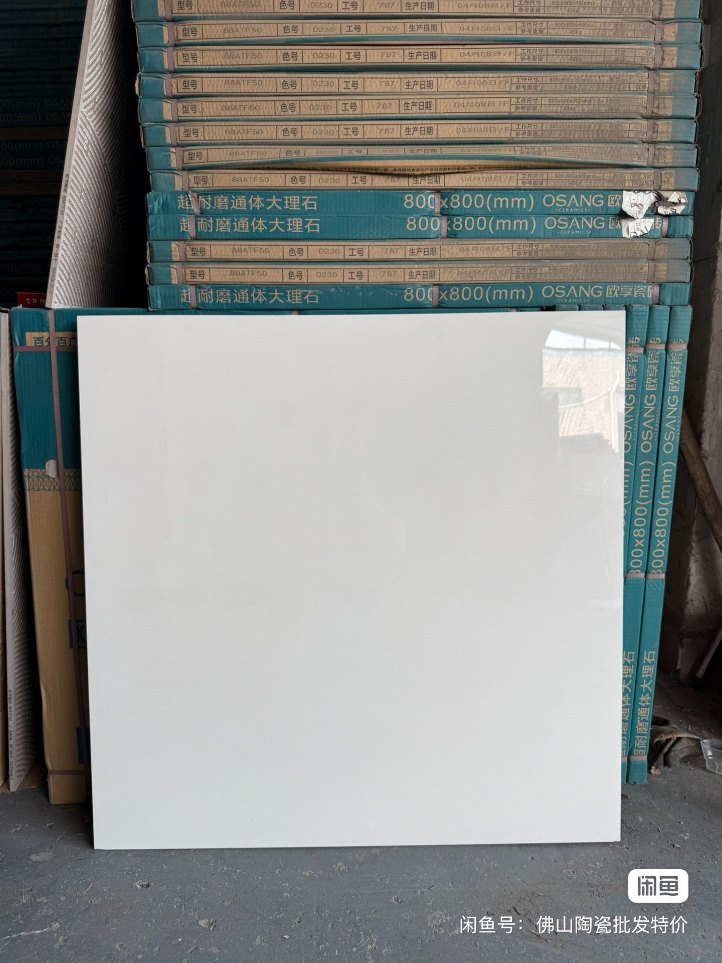Close-up of approved tile shade samples with batch and caliber codes for quality control.