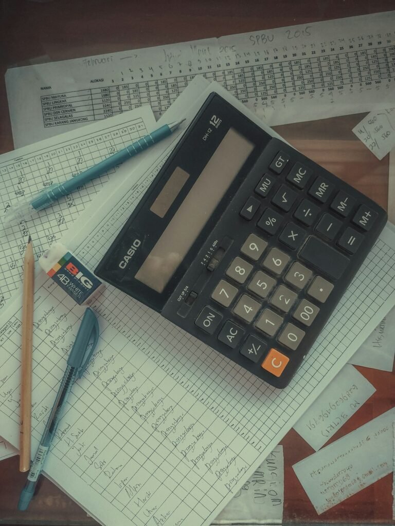 Calculator and cost analysis paperwork used to compare supplier quotations