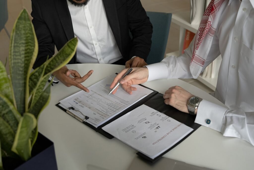 Two people reviewing commercial terms and agent fee structure across a table